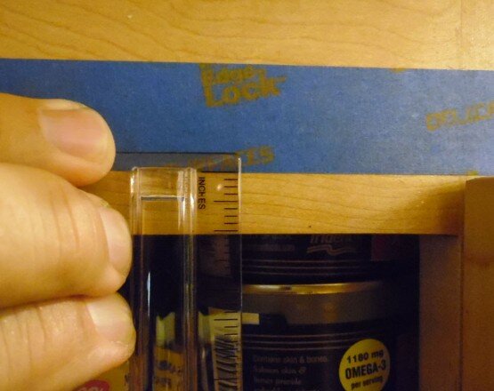 Using blue painters tape to measure your cabinet door overlay